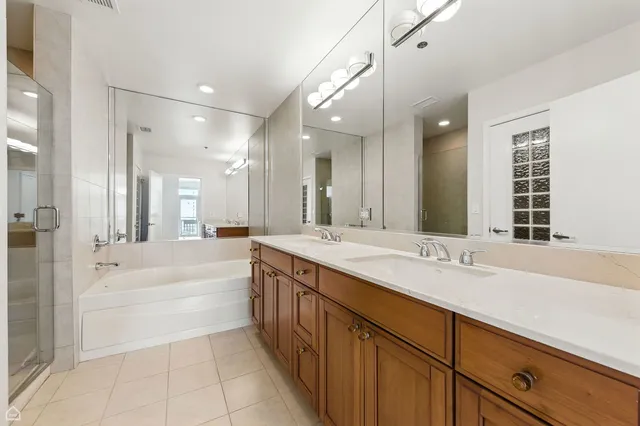 a spacious bathroom with a tub sink shower and mirror
