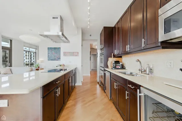 a kitchen with stainless steel appliances sink a stove and cabinets