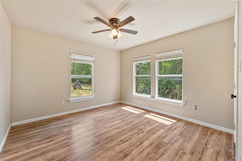 409 Morgan Mill Road Stephenville, TX 76401 - Photo 16 of 25 an empty room with wooden floor and windows