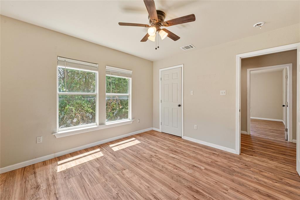 409 Morgan Mill Road Stephenville, TX 76401 - Photo 17 of 25 a view of an empty room with wooden floor and a window