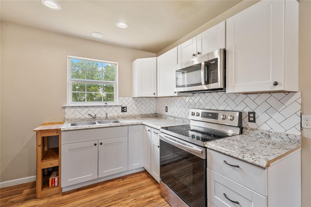 409 Morgan Mill Road Stephenville, TX 76401 - Photo 8 of 25 a kitchen with stainless steel appliances granite countertop a stove a sink and a microwave