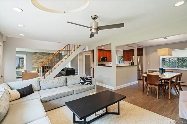 a living room with furniture kitchen view and a window