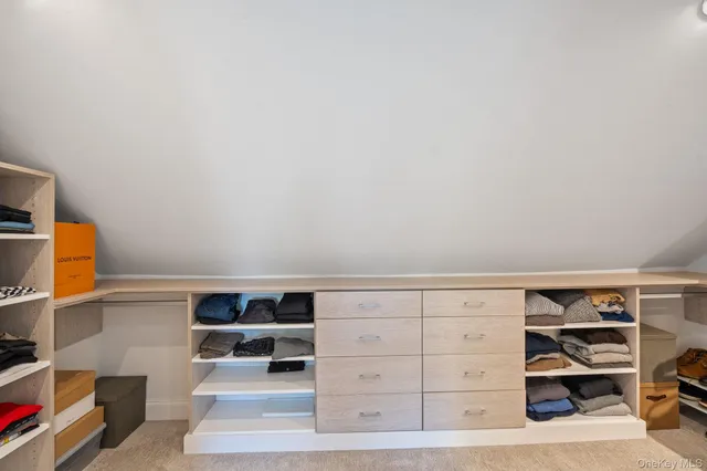 a view of walk in closet with clothes and shoes
