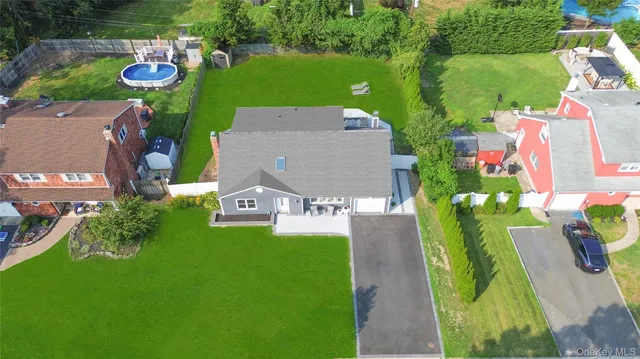an aerial view of a house with a garden and lake view
