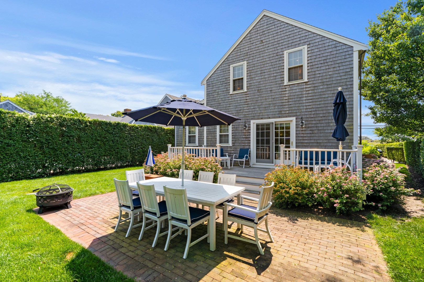 39 A Milk Street Nantucket, MA 02554 - Photo 56 of 56 a view of a patio with table and chairs under an umbrella
