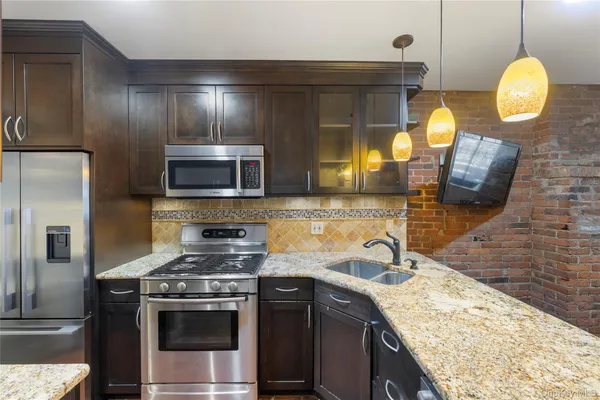 a kitchen with granite countertop stainless steel appliances and wooden cabinets