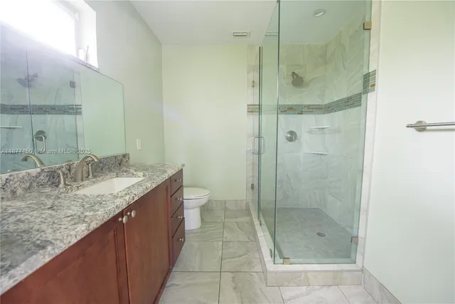 a bathroom with a granite countertop sink a shower and a mirror