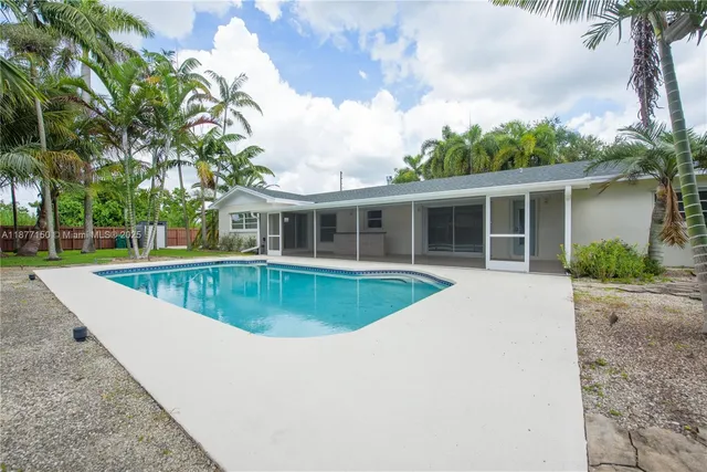 front view of house with swimming pool and yard