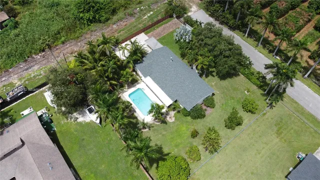 an aerial view of a house with a yard and lake view