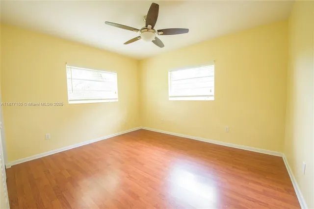 a view of a big room with wooden floor and a ceiling fan