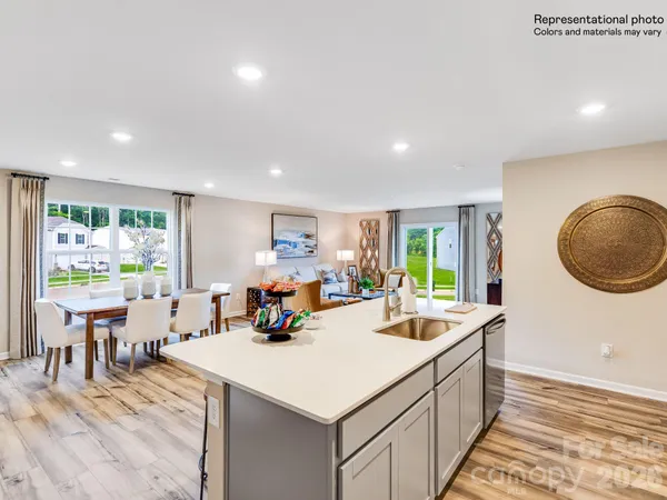 a view of a kitchen area with furniture and wooden floor