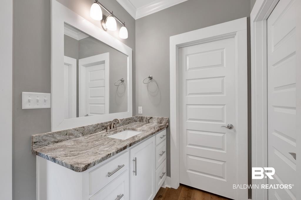379 Pecan Ridge Boulevard Fairhope, AL 36532 - Photo 12 of 21 Vanity featuring a stone countertop, an undermount sink, and a brushed nickel faucet