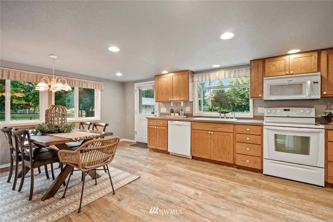 1125 Dyer Road Sultan, WA 98294 - Photo 6 of 22 a kitchen with stainless steel appliances kitchen island granite countertop a stove a sink and a microwave