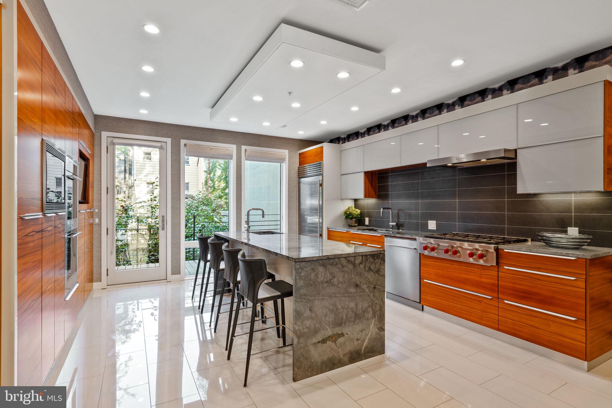 a kitchen with stainless steel appliances granite countertop a refrigerator and a stove top oven