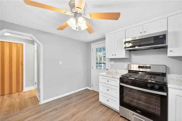 a kitchen with stainless steel appliances a stove a microwave and cabinets