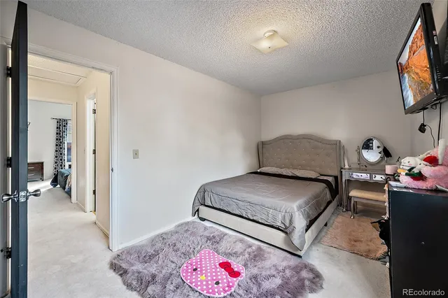 a bedroom with bed and a flat screen tv
