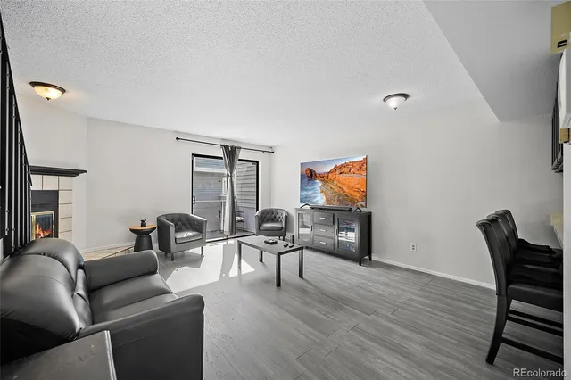 a living room with furniture and a flat screen tv with wooden floor