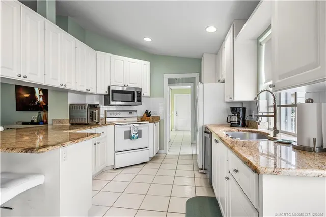 a kitchen with white cabinets sink and stainless steel appliances