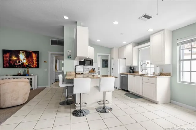 a living room with kitchen furniture and a flat screen tv