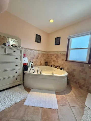 a bathroom with a bathtub and mirror