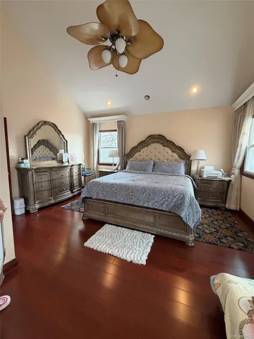 a bedroom with a large bed and wooden floor
