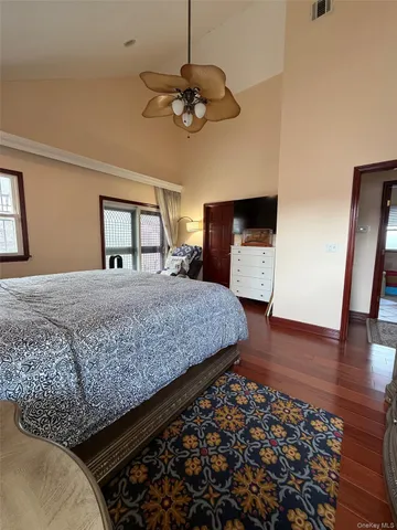 a bedroom with a large bed and a flat tv screen