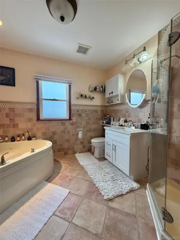a bathroom with a tub sink and mirror