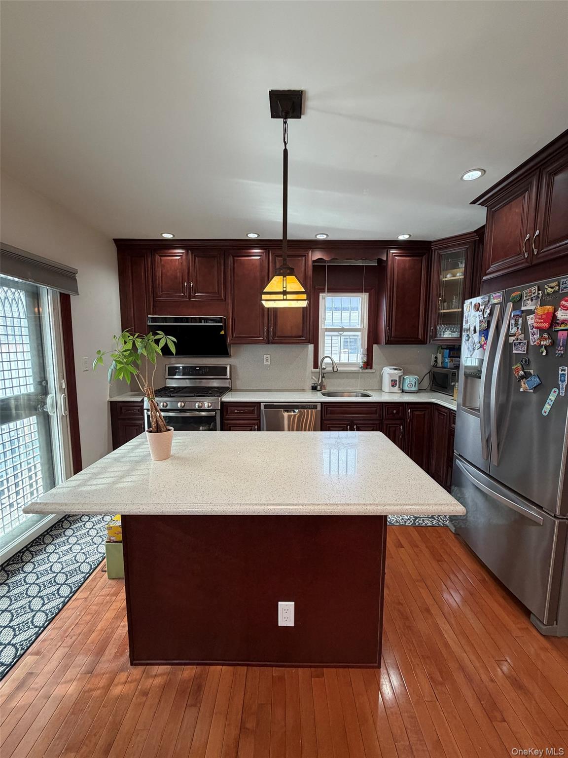 175-28 Underhill Avenue Queens, NY 11365 - Photo 4 of 24 a kitchen with stainless steel appliances granite countertop a refrigerator a stove and a sink with wooden floors