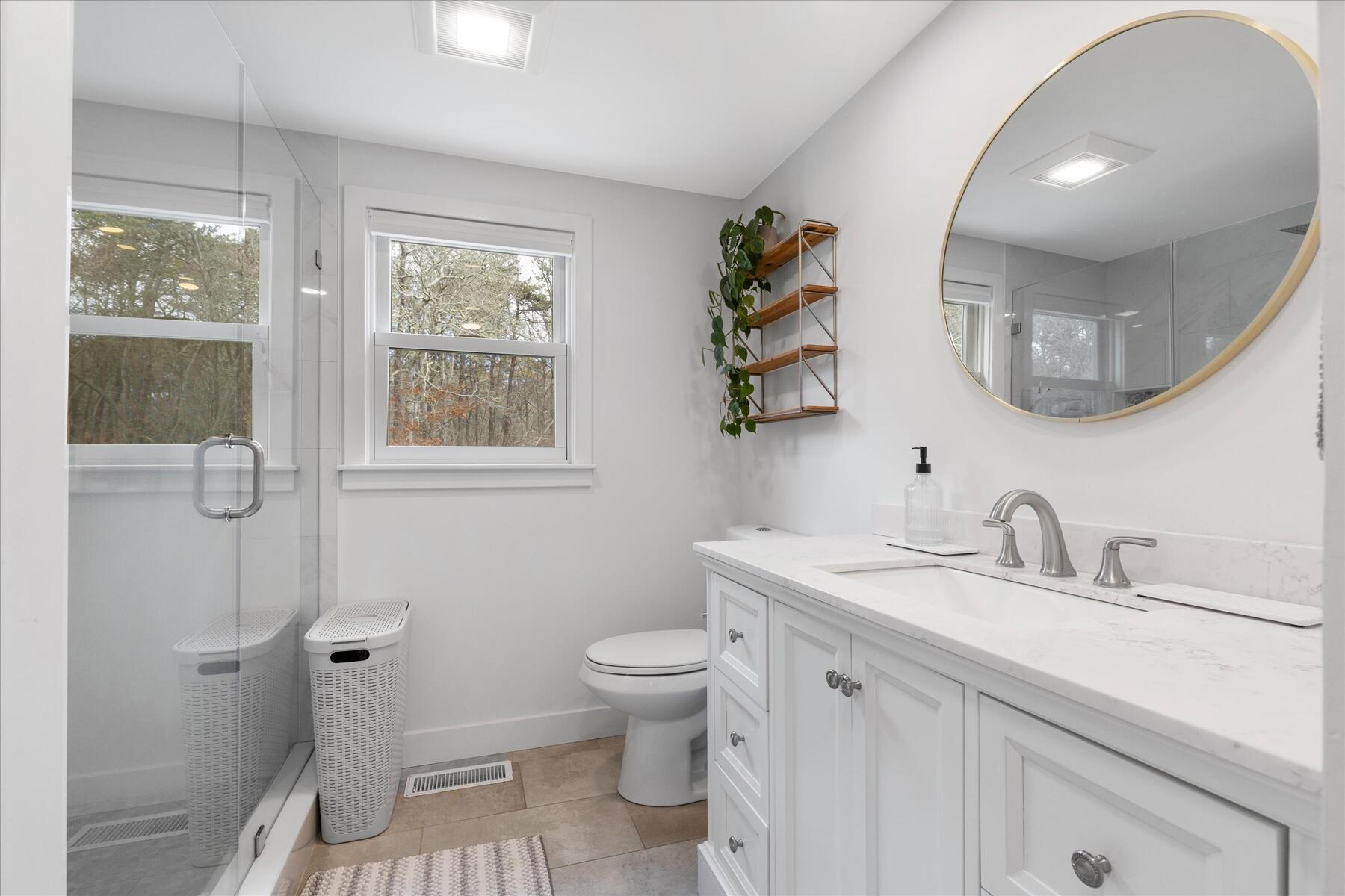 80 Coolidge Road West Yarmouth, MA 02673 - Photo 23 of 37 a bathroom with a toilet a sink a mirror and a window