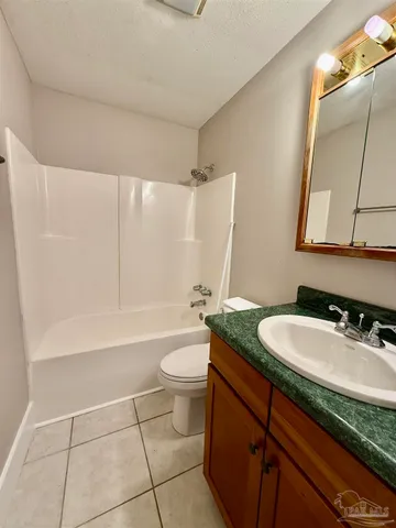 a bathroom with a granite countertop sink a toilet a mirror and bathtub