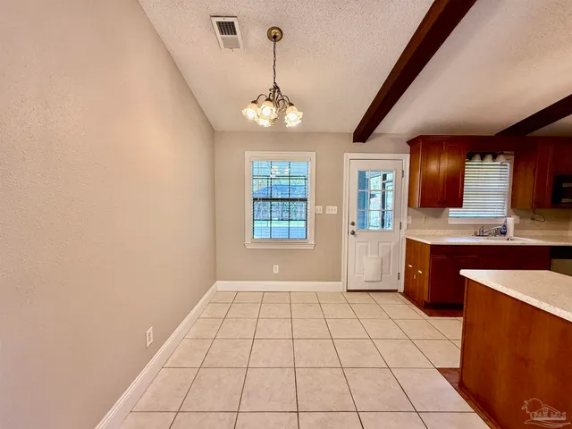a view of an empty room with window and cabinet
