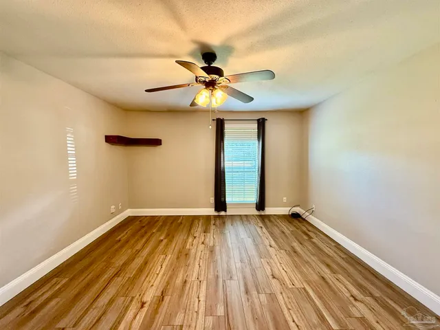 a view of room with a ceiling fan and wooden floor