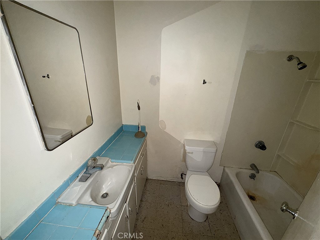 521 East Williams Street Barstow, CA 92311 - Photo 25 of 26 a bathroom with a granite countertop toilet sink and mirror
