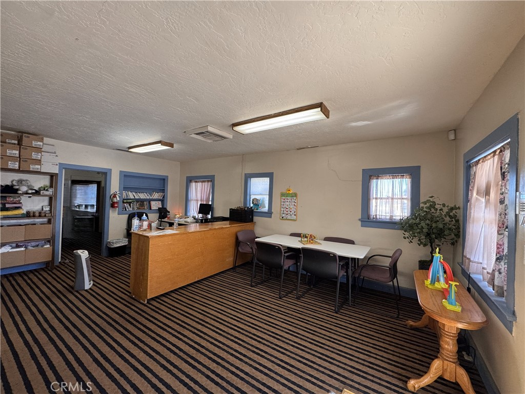 521 East Williams Street Barstow, CA 92311 - Photo 7 of 26 a living room with furniture a flat screen tv and kitchen view