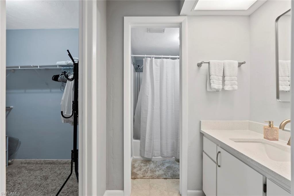3410 Frosty Way, Unit 4802 Naples, FL 34112 - Photo 11 of 27 Full bathroom featuring vanity, shower / bathtub combination with curtain, and a walk in closet