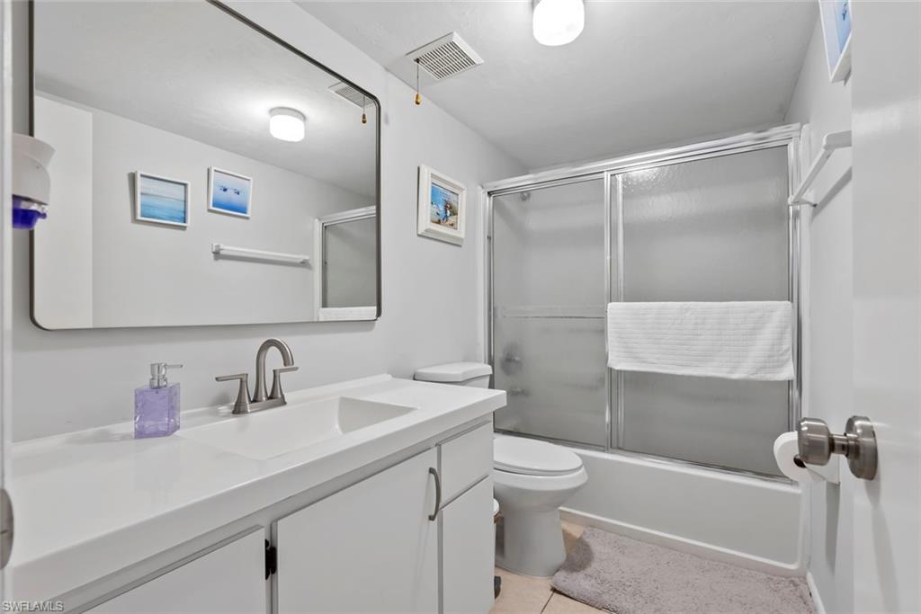 3410 Frosty Way, Unit 4802 Naples, FL 34112 - Photo 14 of 27 Full bath featuring vanity, toilet, combined bath / shower with glass door, and tile patterned flooring