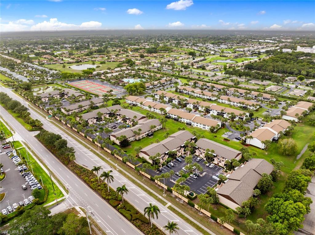 3410 Frosty Way, Unit 4802 Naples, FL 34112 - Photo 18 of 27 Aerial view of property and surrounding area with a large body of water and nearby suburban area