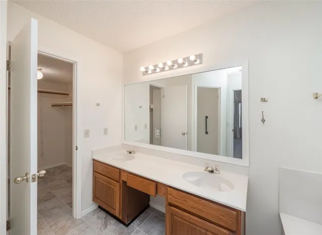 a spacious bathroom with a tub sink and mirror