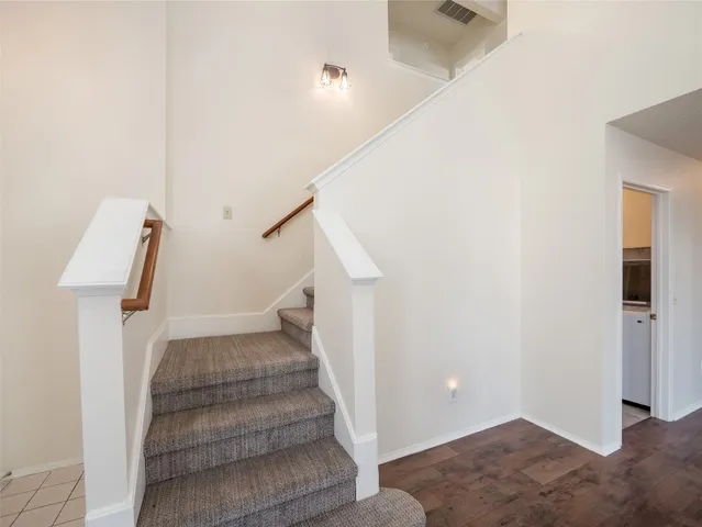 a view of a living room with wooden floor and stairs