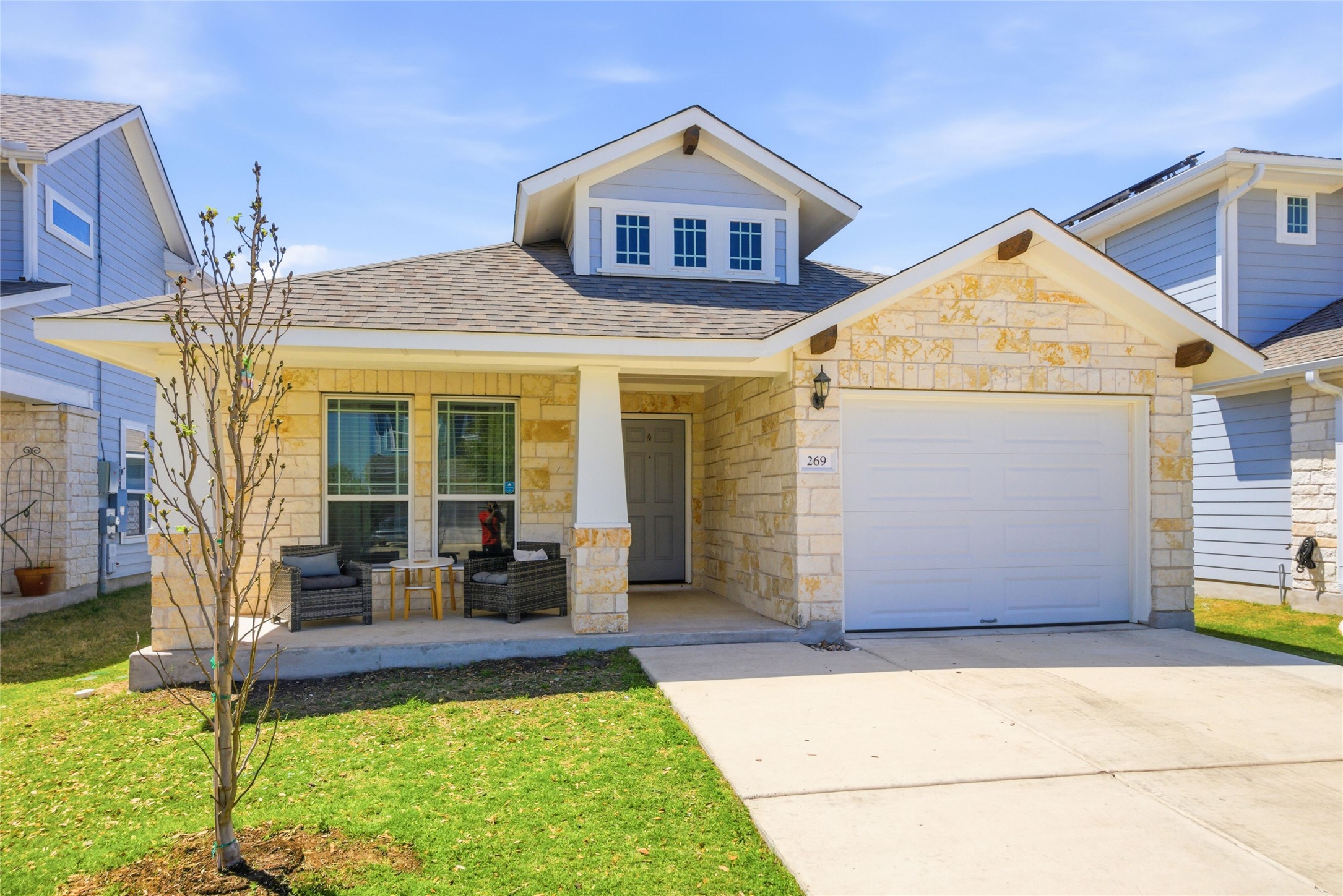 269 Gaida Loop Georgetown, TX 78628 - Photo 20 of 20 View of front facade with stone siding, covered porch, an attached garage, driveway, and a shingled roof