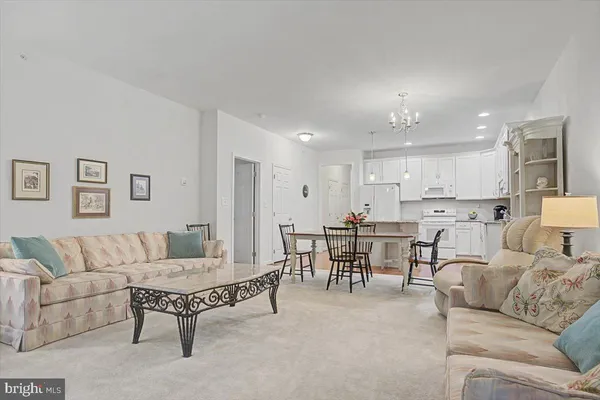 a living room with furniture and a dining table with kitchen view