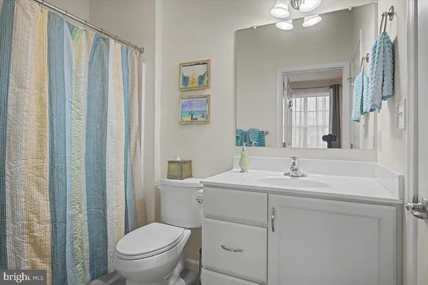 a bathroom with a toilet sink vanity and mirror