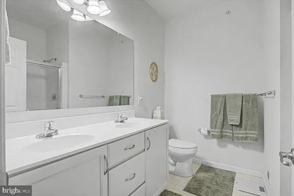 a bathroom with a sink a toilet and a large mirror