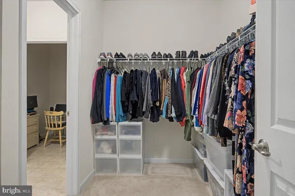 a view of walk in closet with clothes