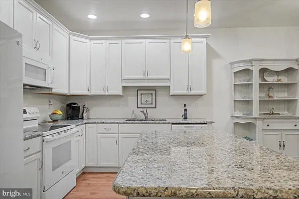 a kitchen with stainless steel appliances granite countertop a sink a stove and cabinets