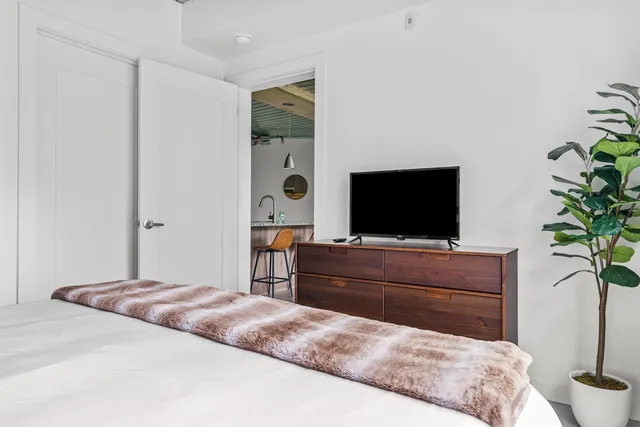a bedroom with a bed and a flat screen tv