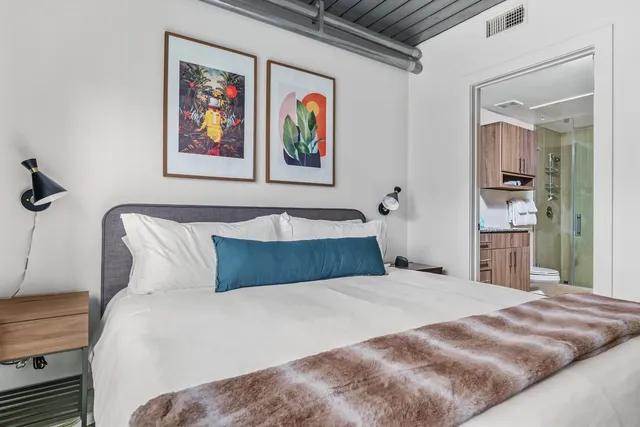 a bedroom with a bed and painting on the wall