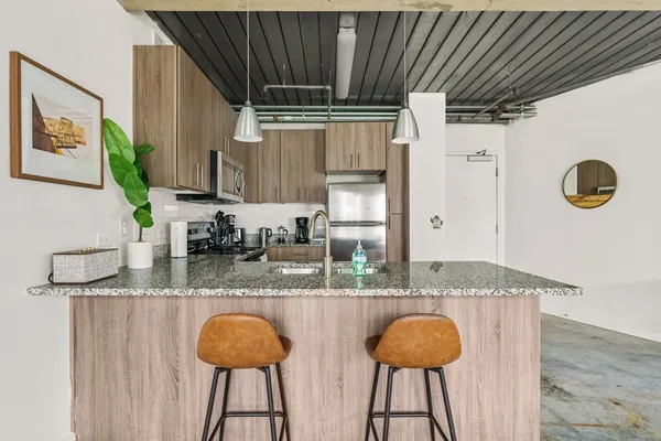 a kitchen with granite countertop a counter space cabinets and stainless steel appliances
