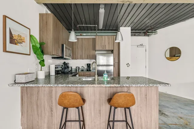 a kitchen with granite countertop a counter space cabinets and stainless steel appliances