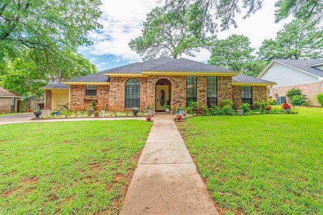 a front view of a house with a yard and potted plants